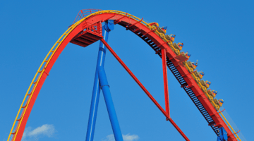 red and yellow roller coaster with blue sky