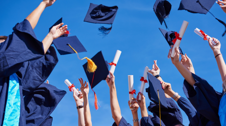 college grads tossing hats 