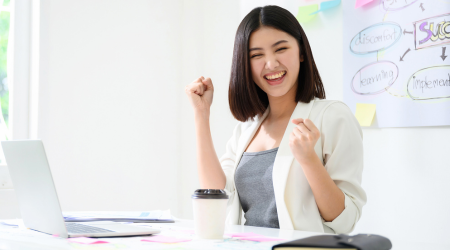 woman at desk cheering