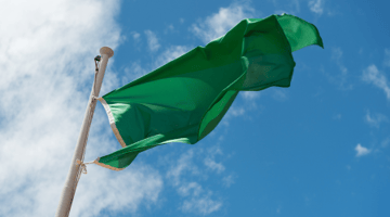 green flag flying on blue sky