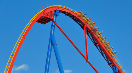 red and yellow roller coaster with blue sky