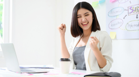 Woman at desk cheering 