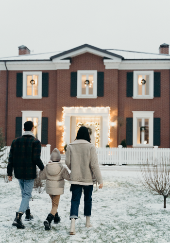 family of 3 touring brink home in the snow