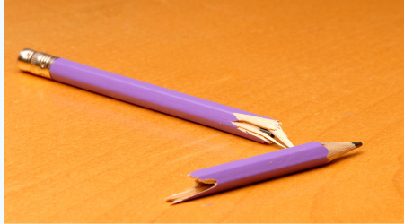 useless broken pink pencil on orange background